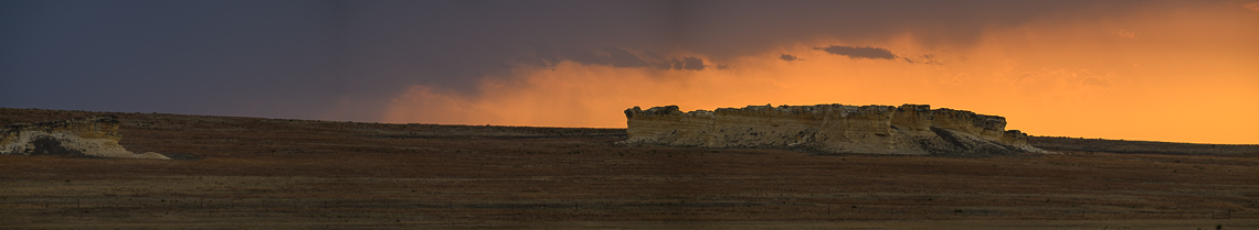 Storm clouds begin to obscure a colorful sunset on the Home Family Farm and Ranch near Healy, Kansas. EDITORS NOTE: Image is a panorama composite of multiple overlapping images.
